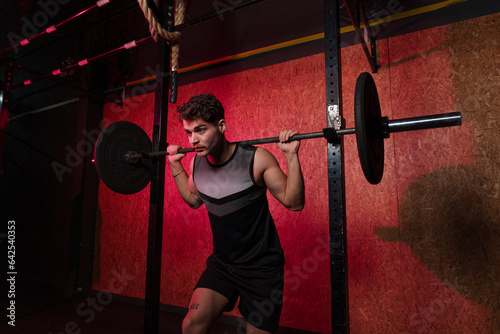 Man focused performing barbell squats