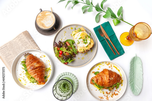Set of breakfast dishes: croissants, toast, scrambled eggs, salad, bruschetta