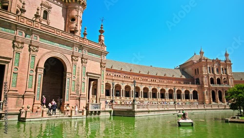 Tourists sailing on the boats in Plaza de España on a beautiful day in Seville. People in the lake exploring Historical most famous landmark Plaza España, Sevilla photo