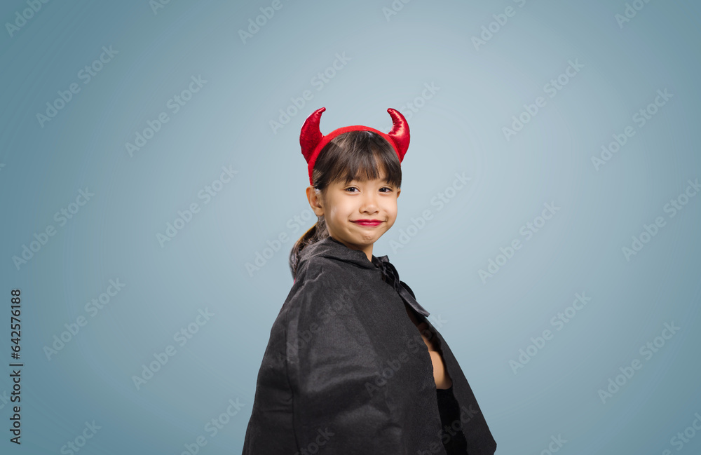 A little girl is wearing a witch costume for Halloween day. A little girl is wearing a witch costume for Halloween day.