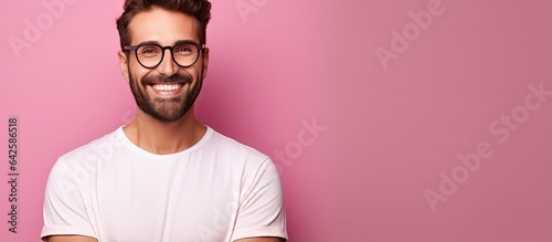 Brunette man with beard poses happily camera in focus on pink background © vxnaghiyev