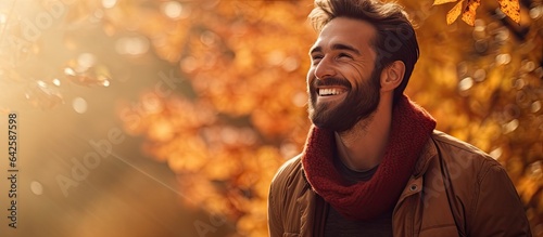 A man smiling in a serene forest during autumn