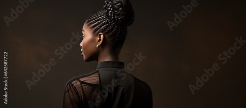 Stylish African American woman with braided hair posing against dark background