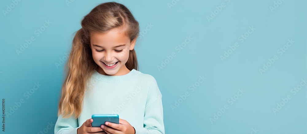 Caucasian child girl posing on blue background with phone Caucasian child girl posing on blue background with phone