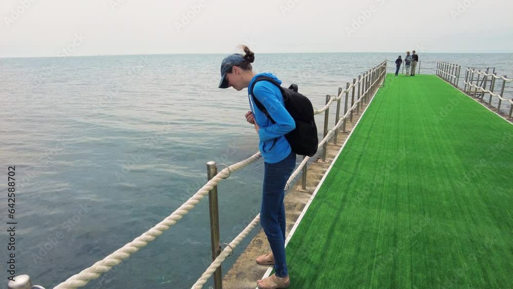 People play with jellyfish along the pier stretching into the Black Sea. People play with jellyfish along the pier stretching into the Black Sea.