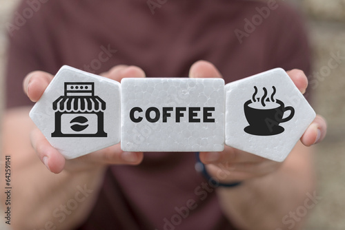 Man holding white foam blocks with icons and word: COFFEE. Concept of coffee shop fast delivery service. Professional modern coffee house.