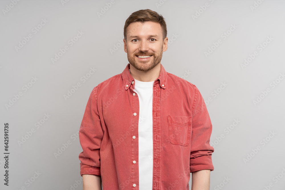 Satisfied man in high spirits think about good offer smiling broadly with white teeth looking confident at camera on grey background. Portrait mature pleased male standing in studio for ad promotion Satisfied man in high spirits think about good offer smiling broadly with white teeth looking confident at camera on grey background. Portrait mature pleased male standing in studio for ad promotion