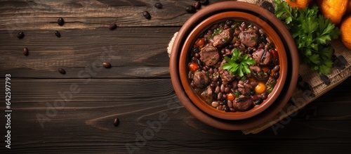 Brazilian feijoada in a ceramic bowl on a rustic wooden background