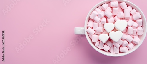 Hearts shaped marshmallows arranged on pink background