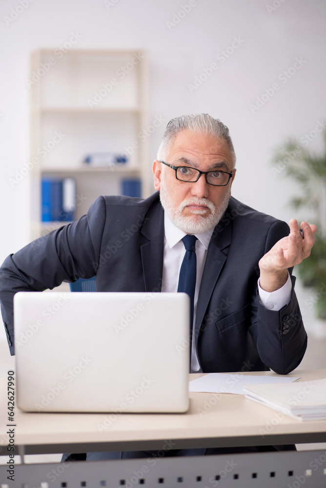 Old male employee working in the office Old male employee working in the office