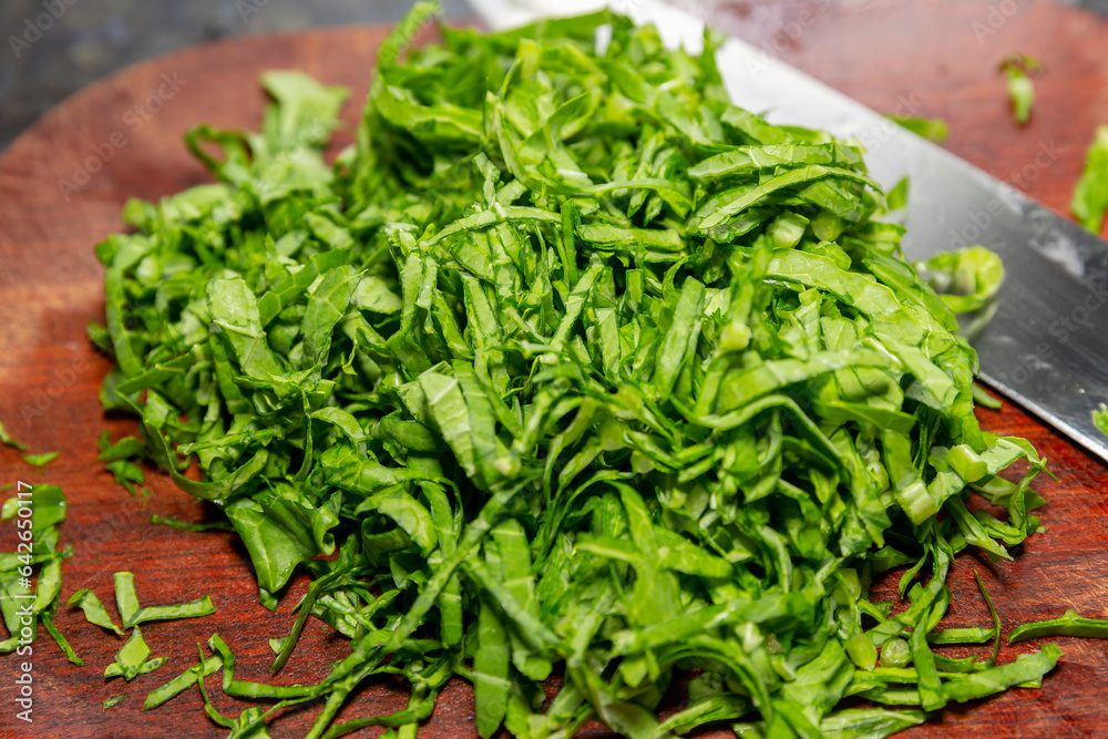 Chopped kale on the rustic board with knife beside Chopped kale on the rustic board with knife beside