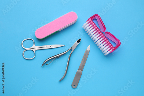 Set of pedicure tools on light blue background  flat lay