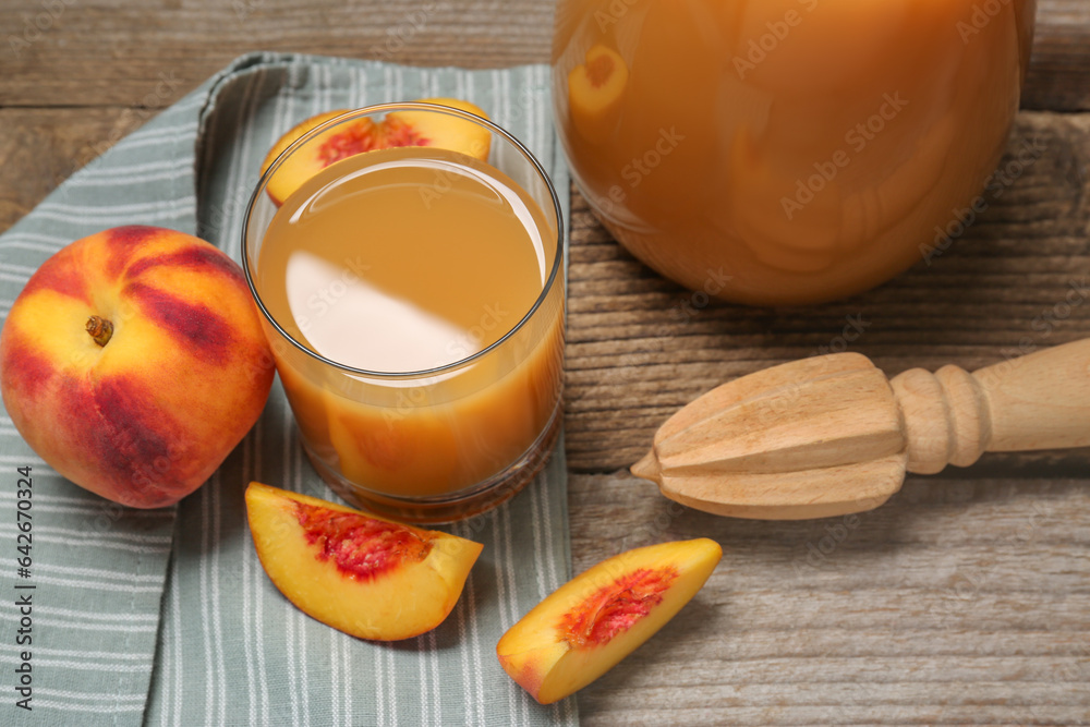Delicious peach juice, fresh fruits and citrus reamer on wooden table, above view Delicious peach juice, fresh fruits and citrus reamer on wooden table, above view