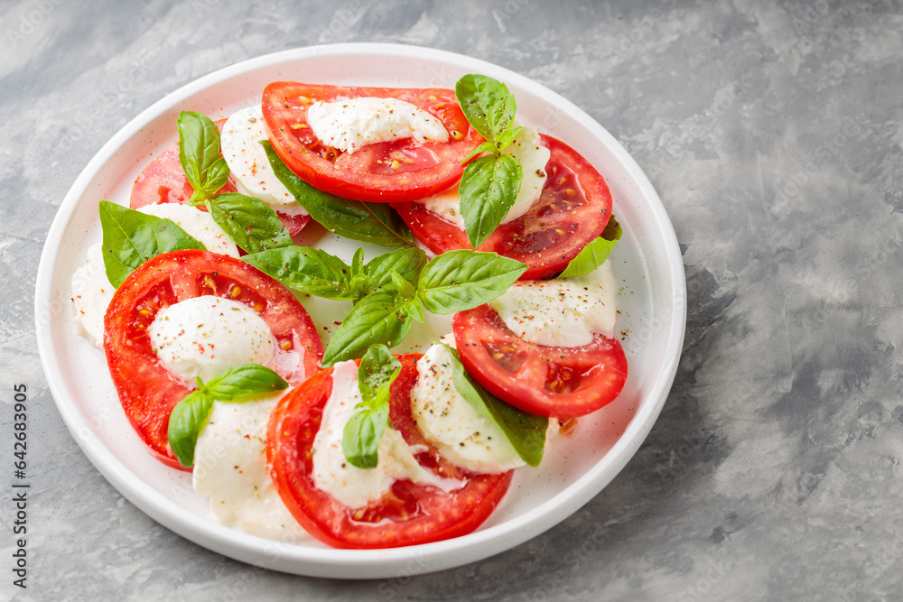 Delectable Caprese Salad on White Plate with Concrete Background. Top View. Copy Space