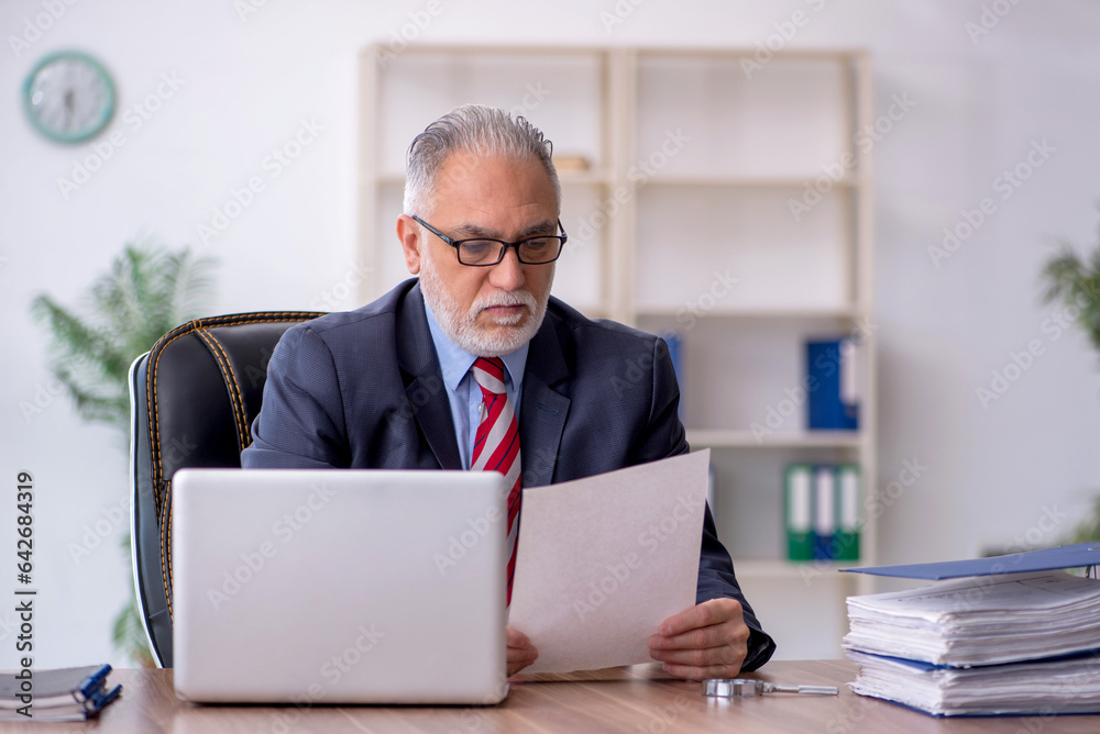 Old male employee working in the office Old male employee working in the office