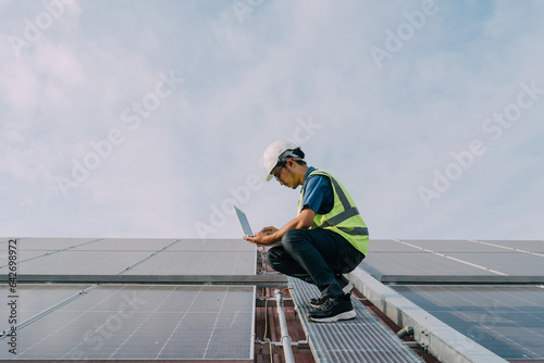 Engineers wearing a uniform walking on roof inspect and check solar cell panel, solar cell is smart ecology energy sunlight alternative power factory concept. © Nabodin