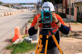 engineer use theodolite equipment  for route surveying to build a bridge across the intersection to reduce traffic congestion during rush hours
