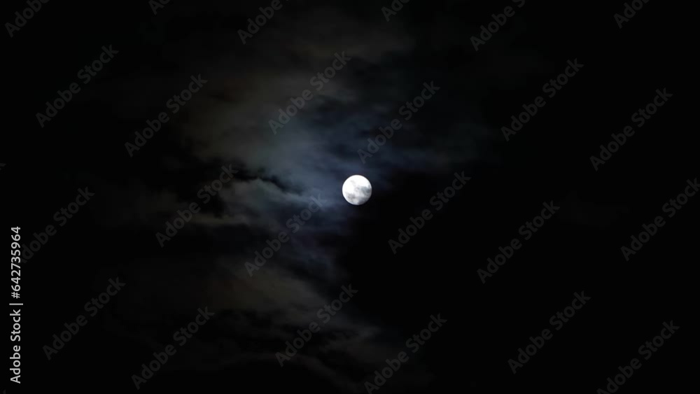 Full moon in the sky with clouds at night. Full moon on a dark cloudy night, an eerie feeling of mysticism. Full moon in the sky with clouds at night. Full moon on a dark cloudy night, an eerie feeling of mysticism.