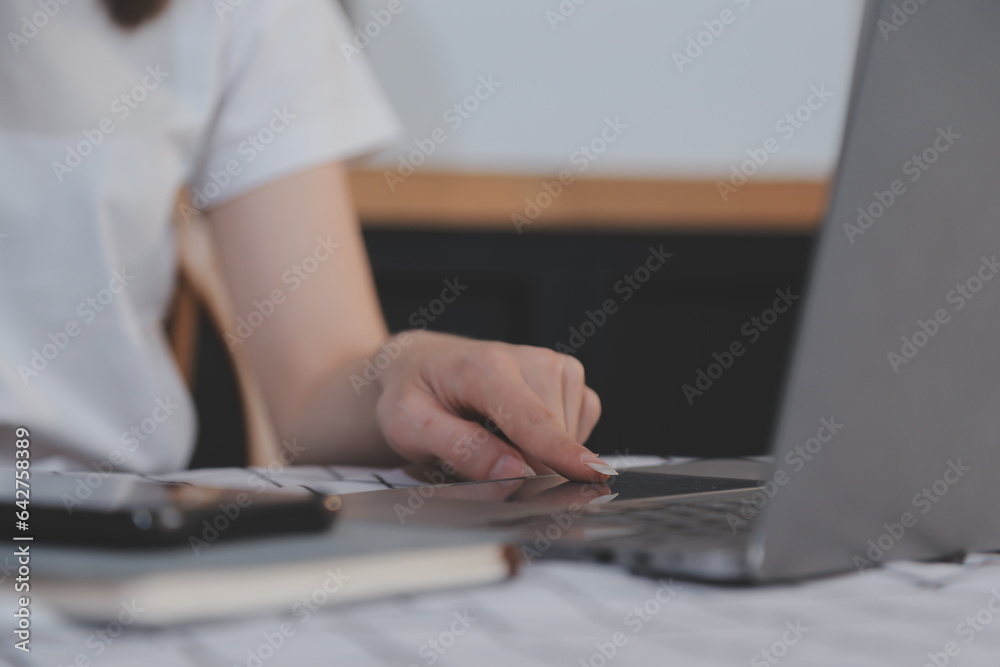 Cropped photo of Freelancer business Asian woman holding coffee cup and at doing planning analyzing the financial report, business plan investment, finance analysis the workplace. Cropped photo of Freelancer business Asian woman holding coffee cup and at doing planning analyzing the financial report, business plan investment, finance analysis the workplace.