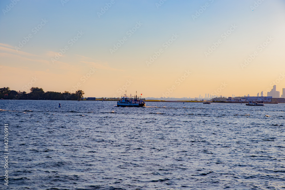 Sunset view of Toronto and water taxi in lake Ontario