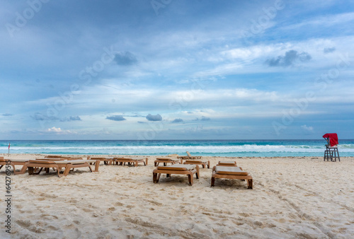 Afternoon with empty lounge chairs on empty beach at Zona Hotelera  Hotel Zone  on a cloudy day in Cancun  Mexico