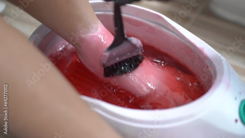 Beautiful Asian young woman having a paraffin foots and hands spa at beauty - spa shop. Foot and hand paraffin treatment. photo