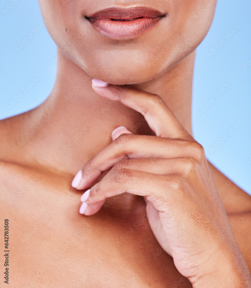 Fototapeta premium Hand, mouth and beauty with a woman closeup in studio on a blue background for natural skin wellness. Skincare, lips and finger of a model touching her face for an aesthetic manicure or cosmetics