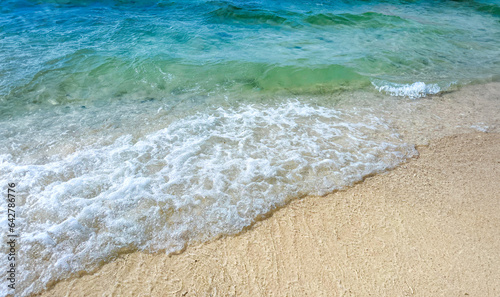 Beach sand background for summer vacation concept. Beach nature and summer seawater with sunlight light sandy beach Sparkling sea water contrast with the blue sky