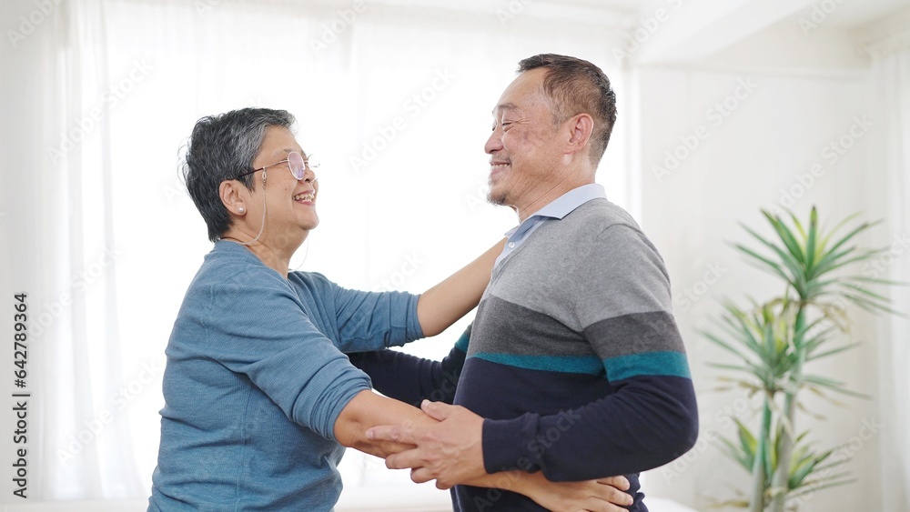 Happy asian senior couple enjoy dancing together in living room at home. Sweet elderly couple enjoy love moment. Retirement lifestyle of asian couple senior concept Happy asian senior couple enjoy dancing together in living room at home. Sweet elderly couple enjoy love moment. Retirement lifestyle of asian couple senior concept