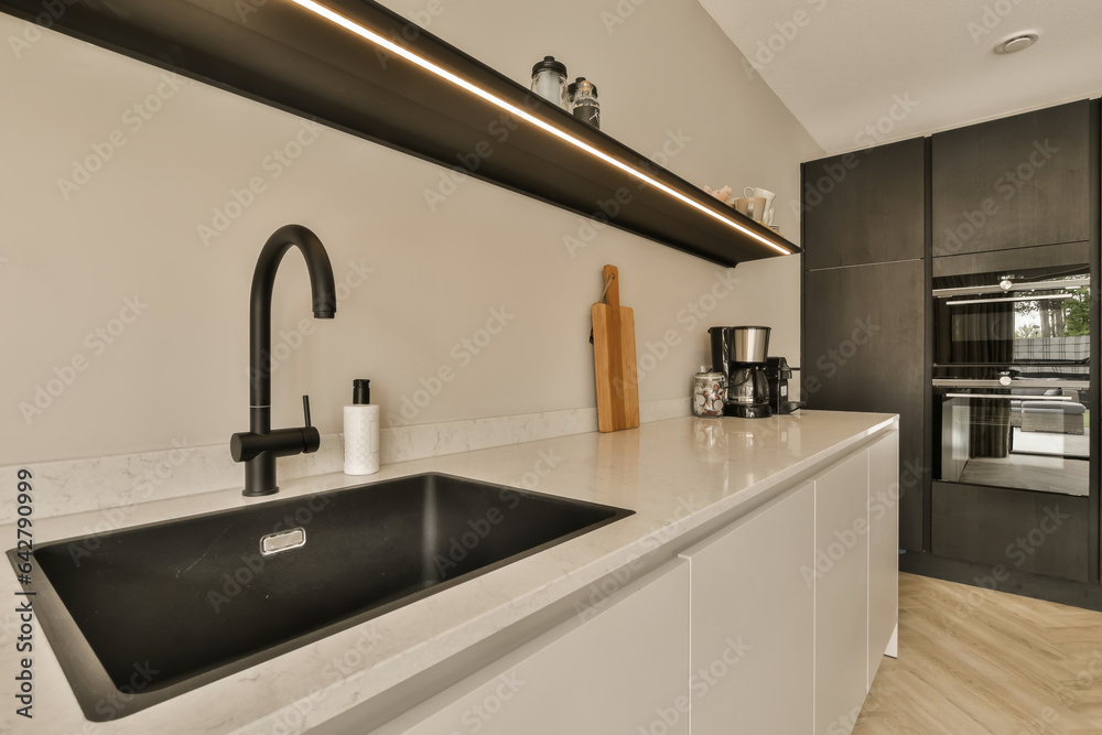 a modern kitchen with black and white appliances on the countertop, along with an island sink in the center a modern kitchen with black and white appliances on the countertop, along with an island sink in the center