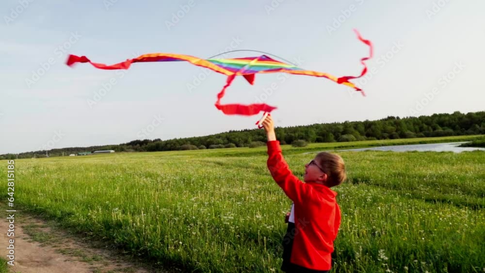 a boy with a kite runs across the field