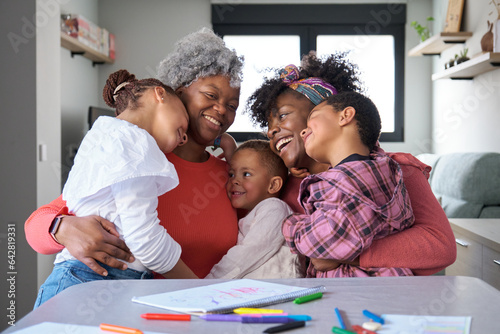 Portrait of a happy african horizontal extended family hugging and laughing at home. photo