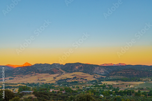 landscape of the valley of ronda at sunrise with the sky colored by the sun and the mountains illuminated with colors. © JOSEANTONA