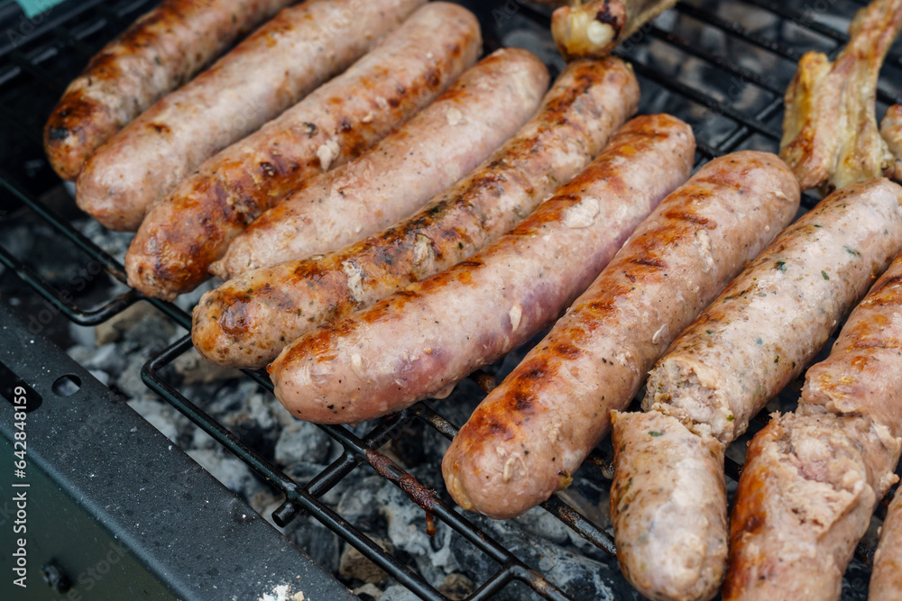 Flame-grilled sausages on a barbecue grill, appetizing and mouthwatering.