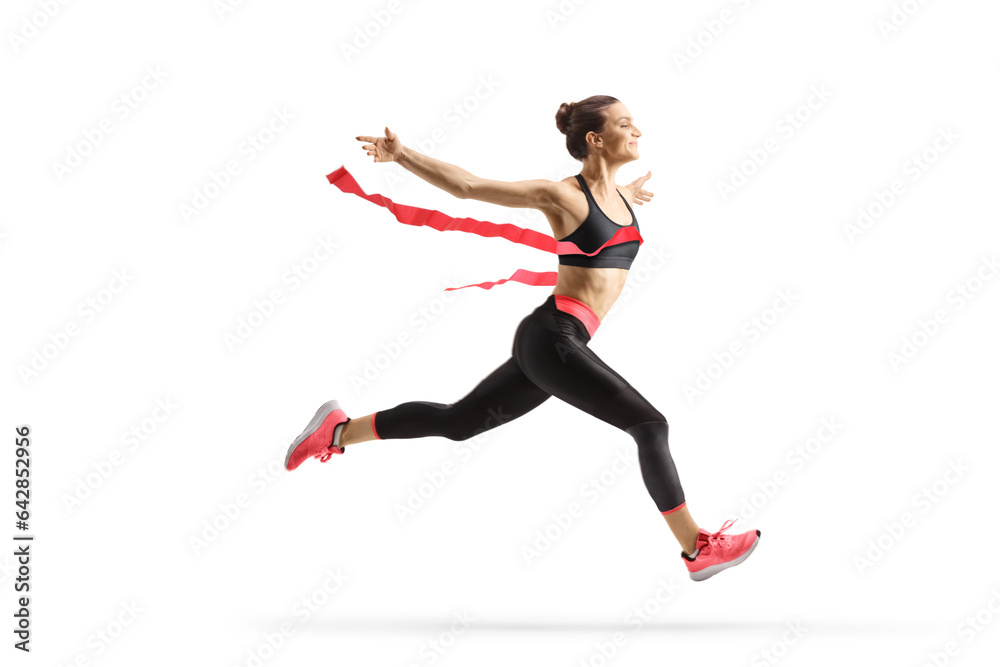 Full length profile shot of a female athlete finishing a race
