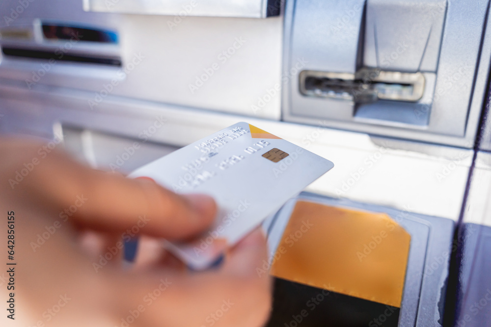 Young woman using the card for withdrawing the cash in the ATM Young woman using the card for withdrawing the cash in the ATM