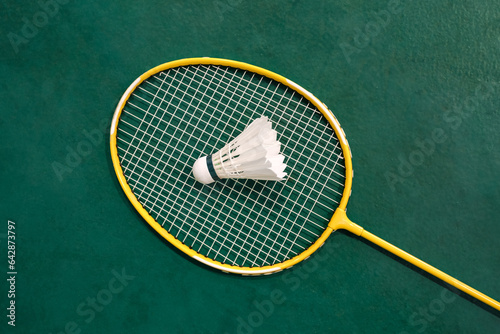 Yellow badminton racket and white badminton shuttlecock