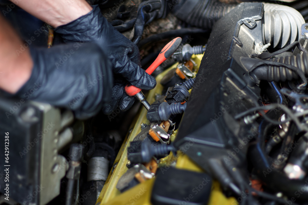 Hands of a master repairing the engine of an old European car. Hands of a master repairing the engine of an old European car.