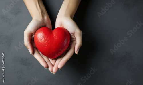 Hand giving red heart , charity symbol	