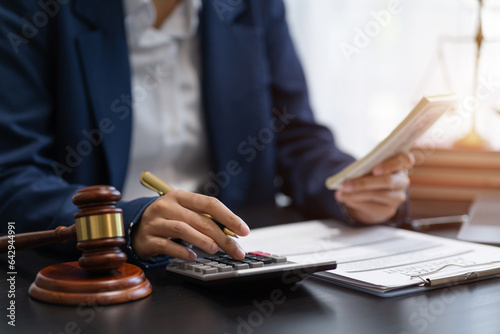 Lawyer or accounting department writes a note and uses a calculator to calculate expenses - income. at office lawyer.