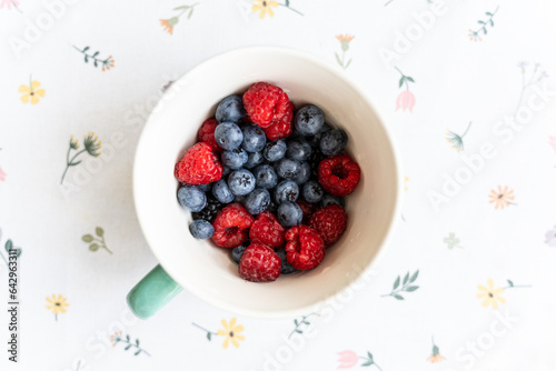 Mix various of summer berries, wild berries in a ceramic bowl, top view.
