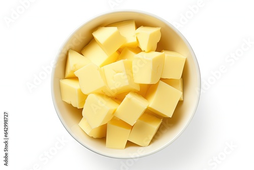 Top view of isolated butter pieces in a bowl on a white background