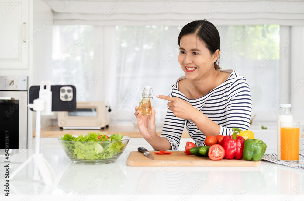 Young woman video blogger cooking salad healthy food at the kitchen and filming Young woman video blogger cooking salad healthy food at the kitchen and filming