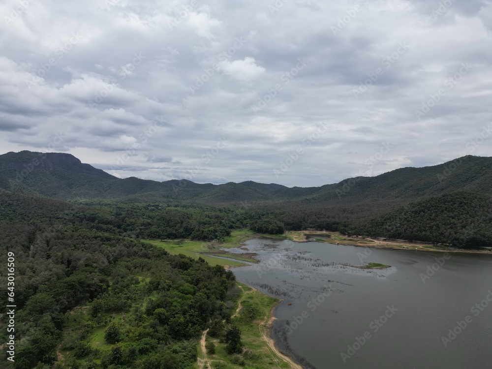 Beautiful natural scenery of a river in Southeast Asia, tropical forest with mountains in the background, aerial view, drone shot.