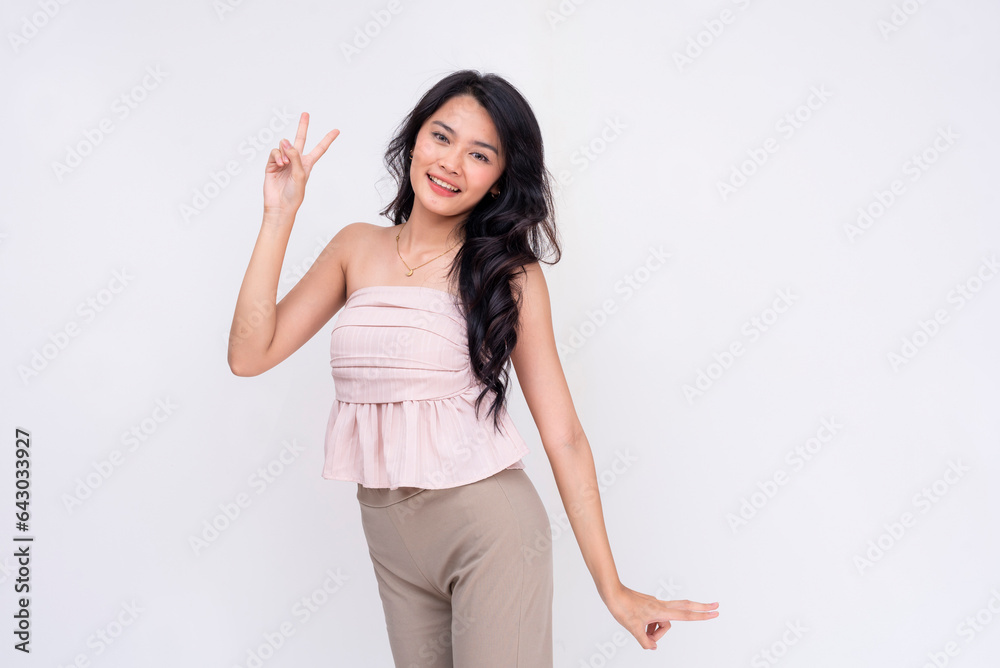 A cute and attractive asian teenage woman smiling while making double peace signs. Isolated on a white backdrop A cute and attractive asian teenage woman smiling while making double peace signs. Isolated on a white backdrop
