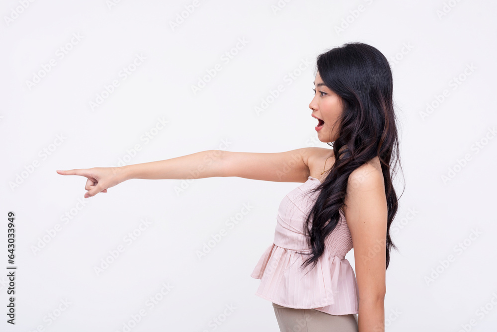 A young amazed asian woman pointing to her left with her finger. Isolated on a white background. A young amazed asian woman pointing to her left with her finger. Isolated on a white background.