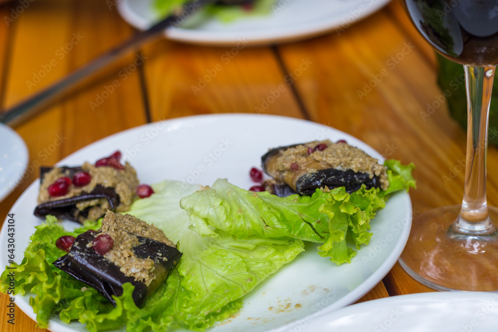Eggplant roulade stuffed with walnuts and pomegranate fruit. Georgian appetizer. Eggplant roulade stuffed with walnuts and pomegranate fruit. Georgian appetizer.