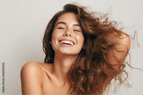 Charming Asian teenager with wavy long hair blowing in the breeze exudes positivity with a bright smile on a solid background. Generative AI.