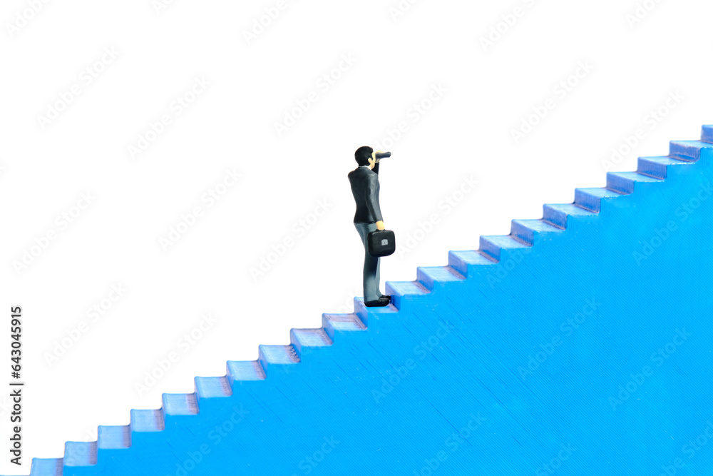 Miniature tiny people toys photography. Businessman using binocular telescope walking up the stair. Isolated on a white background Miniature tiny people toys photography. Businessman using binocular telescope walking up the stair. Isolated on a white background