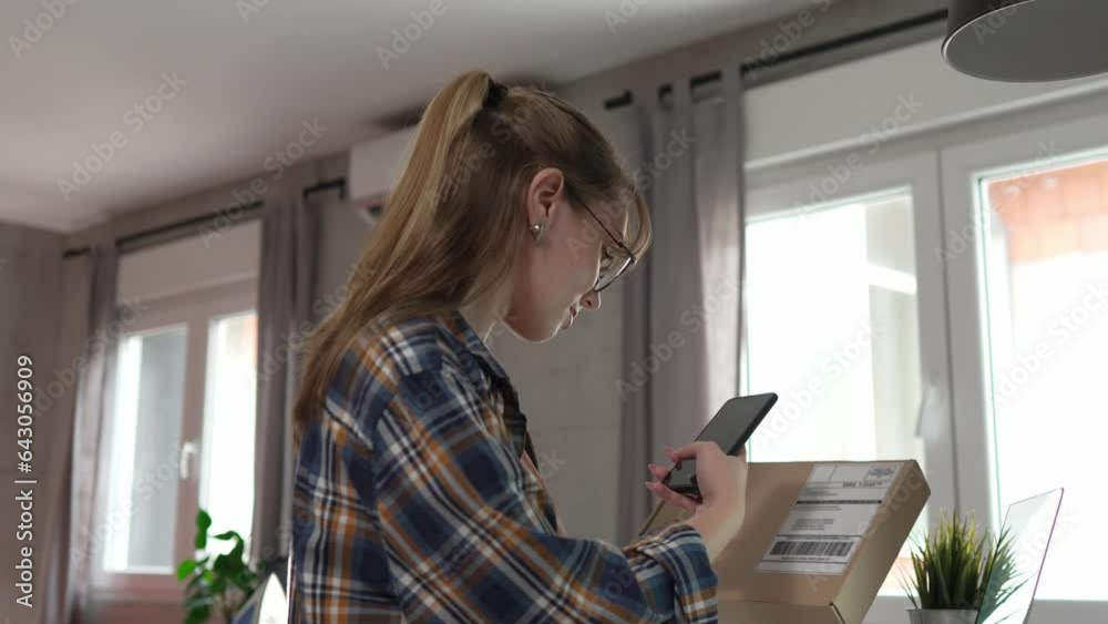one woman checking box of received package or product at home